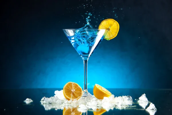 top-view-delicious-cocktail-glass-goblet-served-with-lemon-slice-ice-blue-background_140725-130475